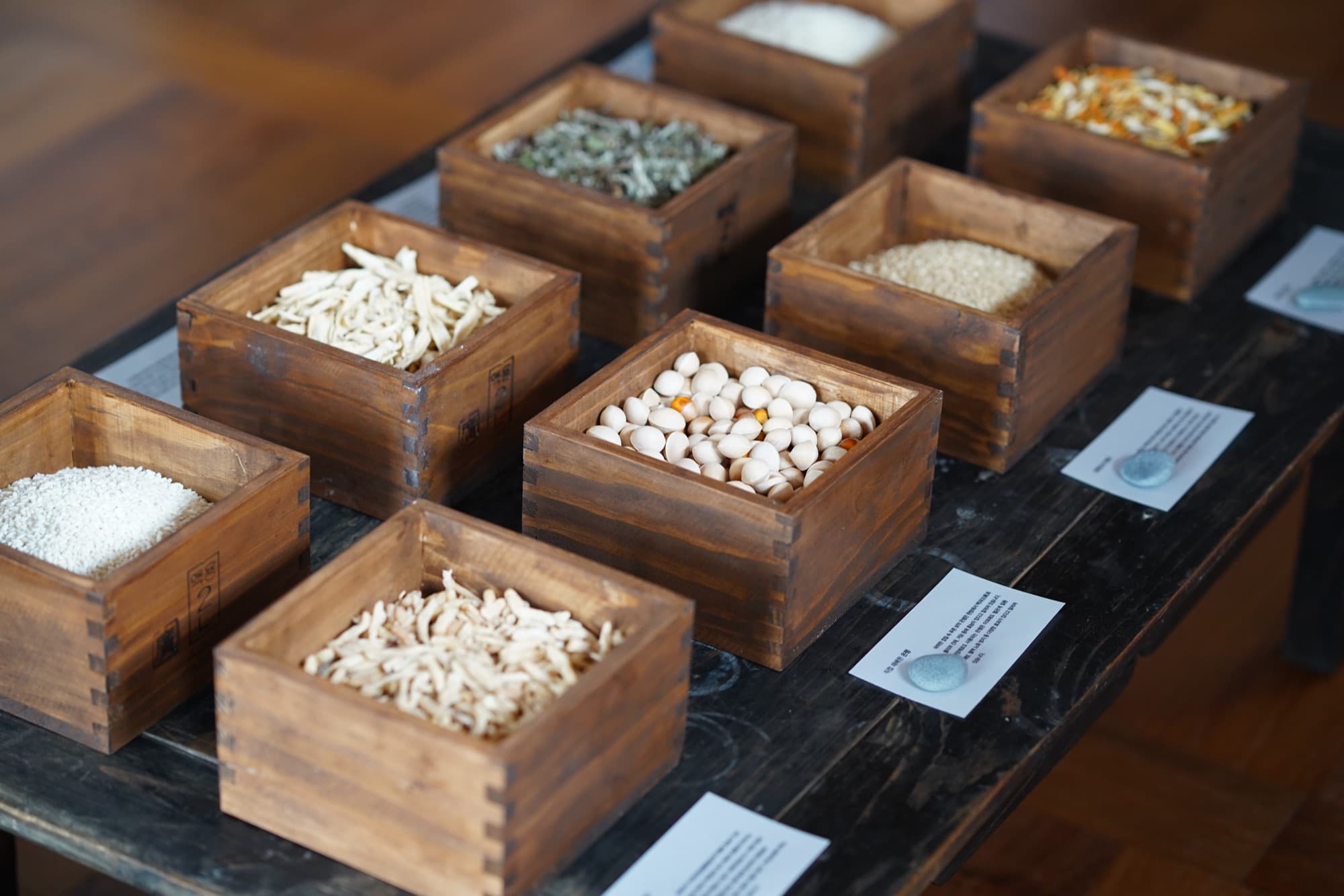 Korean fermentation ingredients laid out in wooden boxes, each labelled